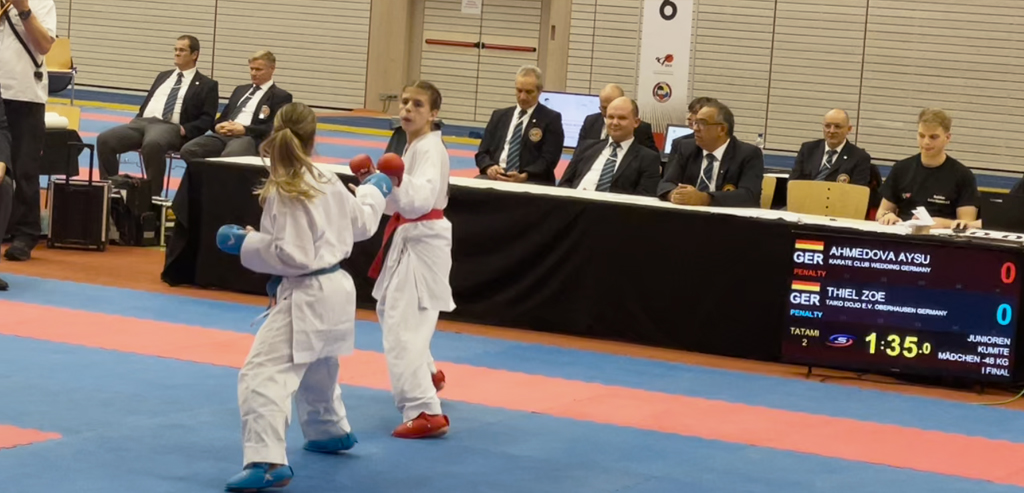 Weibliche Karateka in Kampfpose während des Finales der Deutschen Meisterschaft 2023 in Kaiserslautern. Sie trägt ihren Karate-Gi und ist konzentriert, während sie sich auf ihren Gegner vorbereitet.
